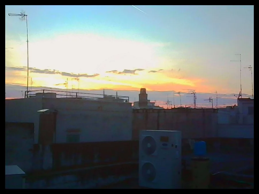 A sunset over rooftops, with a black border
